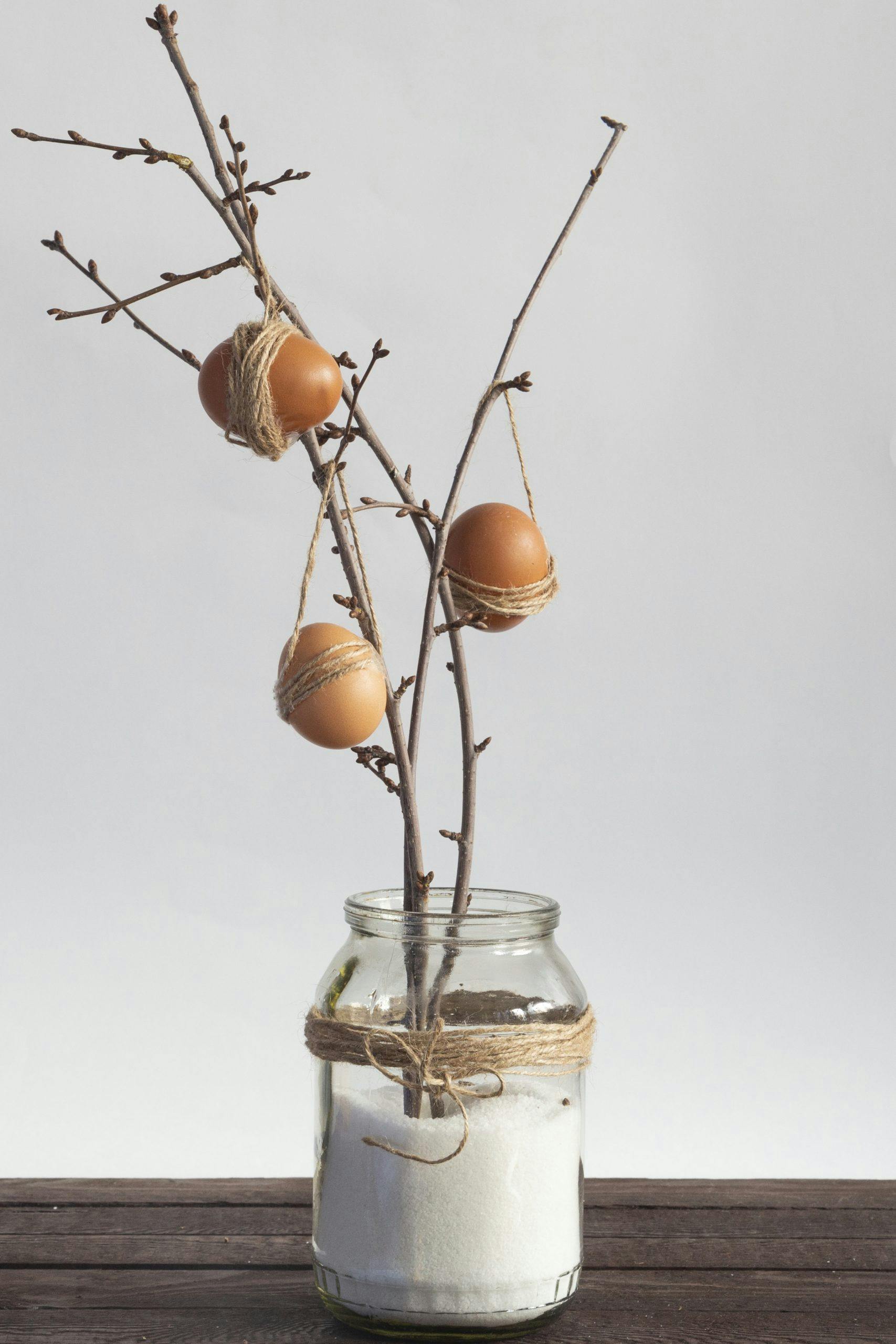Easter eggs hanging on branches in the glass jar hjemmelaget påskepynt ideer påskepynt